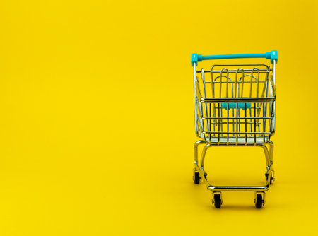 Empty shopping cart in yellow background with copyspace. retail storeの写真素材