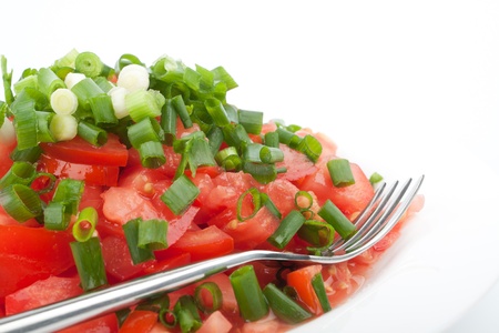 Tomato salad with spring onion on the white backgroundの写真素材