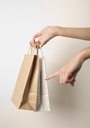 Holding paper bags. Consumerism symbol.の写真素材