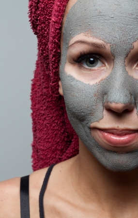 Clay facial mask. The portrait of young woman.の写真素材