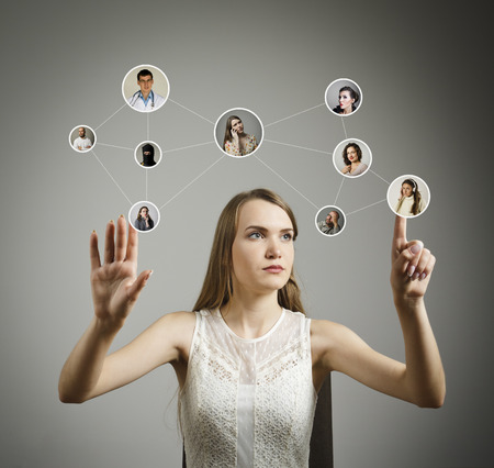 Girl in white is pushing the virtual button. Communication and social network concept.の写真素材