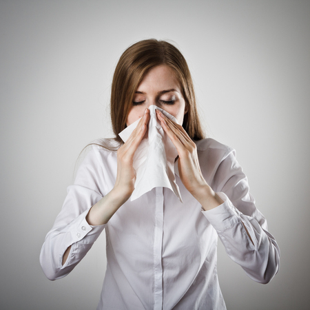 Young slim woman is sneezing.の写真素材
