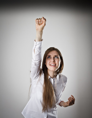 Rejoicing young woman in white. Success and winner concept.の写真素材