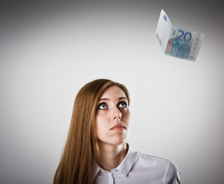Woman in white and falling twenty Euro banknote.の写真素材