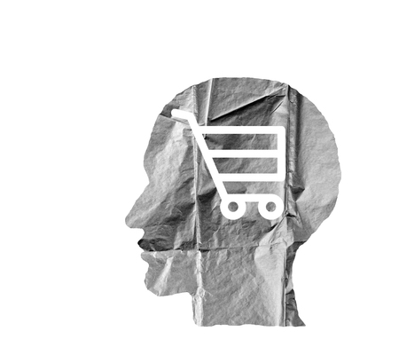Crumpled paper shaped as a human head and shopping cart on white background. Safety and secrets concept.の写真素材