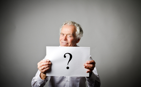 Old man and question mark. Old man in white having no answers to a question.の写真素材