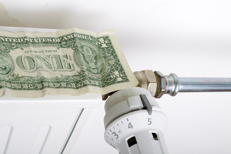 Radiator and one dollar. Money on heating battery. Heating season concept.の写真素材