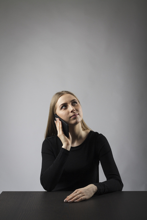 Young woman in black on the phoneの写真素材