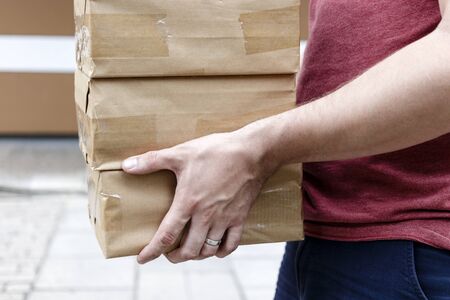 Package delivery. Delivery man is holding packaging or cardboard boxes. Delivery man at work.の写真素材