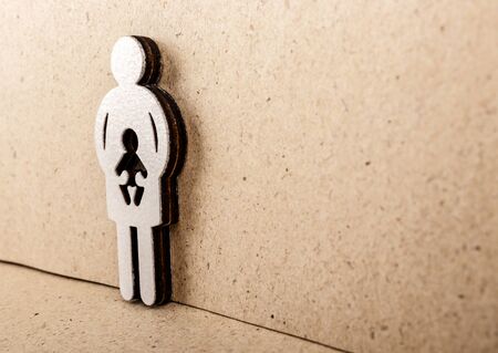 Mother and child. Wooden figure on brown paper background. Pregnancy, abortion or adoption concept.の写真素材
