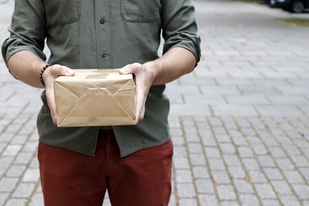 Package delivery. Delivery man is holding packaging or cardboard boxes. Delivery man at work.の写真素材