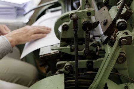 Machine for stitching book pages with threads in typography. Machine for sewing books and notebooks...