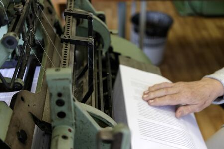 Machine for stitching book pages with threads in typography. Machine for sewing books and notebooks...