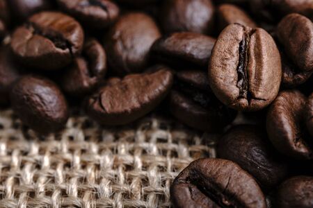 Coffee beans on burlap background. Macro.の写真素材