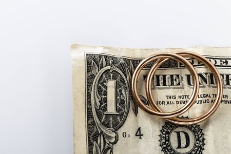Two wedding rings and currency. Wedding rings and one dollar. Wedding or divorce concept. Wedding Planning concept. Expenses.の写真素材