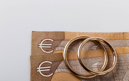 Two wedding rings and currency. Wedding rings and fifty euro. Wedding or divorce concept. Wedding Planning concept. Expenses.の写真素材