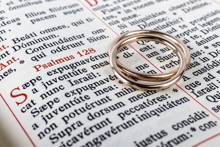 Two wedding rings on a bible page. Wedding rings and psalm. Wedding symbol and concept.