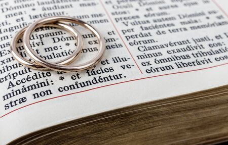 Two wedding rings on a bible page. Wedding rings and psalm. Wedding symbol and concept.