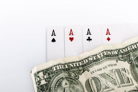 Four aces, playing cards close up lying on top of United States Currency. Gambling, winning concept. Gambling entertainment. Play games of chance for money.の写真素材