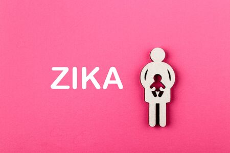 Mother and child. Wooden figure on pink background. Pregnancy and zika virus concept. Pregnant woman.の写真素材