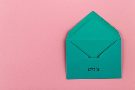 Colorful envelope on a pink background. Message to the world from Covid-19. COVID-19 crisis and...