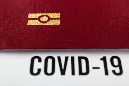 Coronavirus and travel concept. Passport and note COVID-19. Border control and quarantine of tourists infected with coronavirus. Macro shot.の写真素材