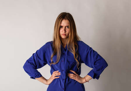 Anger. Angry young woman in blue. Aggression and psychological violence.