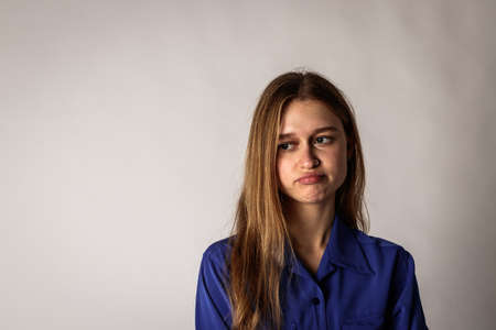 Bored young woman in blue. Depression, boredom and sadness.