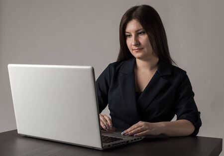 Young woman in blue using a laptop to browse the net.