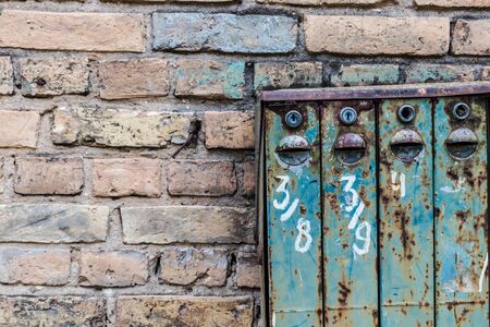 Old Soviet-style mailboxes. Old metal and numbered mailboxes on brick wall. Correspondence.