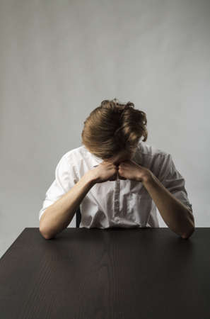 Tired young man. Frustration, overtime and fatigue concept. Feeling unwell. Bad condition and poor health.の写真素材