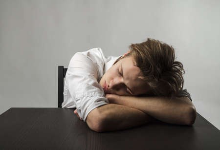 Tired young man. Frustration, overtime and fatigue concept. Feeling unwell. Bad condition and poor...