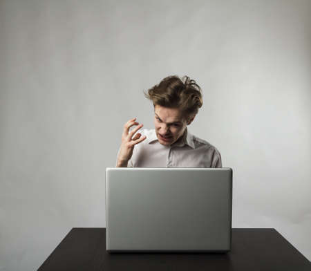 Angry man in white. Frustrated and disappointed young man with laptop. Expressions, feelings and...