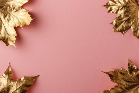 Golden Maple leaves. Golden leaves on pink background. Minimal autumn concept with copy space.の写真素材