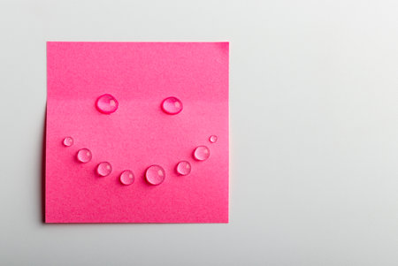 Pink sticky note on a bright background with copy space. Happy and smile concept. Tears of joy.