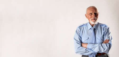 Old man looking at the camera on gray background with copy space. Portrait of a bearded old man....