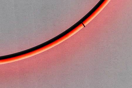 Detail of neon ring. Element of pink neon circle on the gray wall background with reflection. Copy space banner. Lights.の写真素材