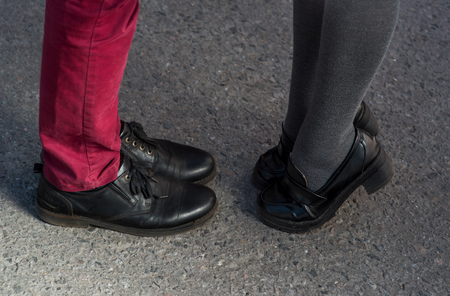 Valentines Day legs man and woman couple pants asphalt shoes sandals manicure. Black elegant lether shoes.の写真素材