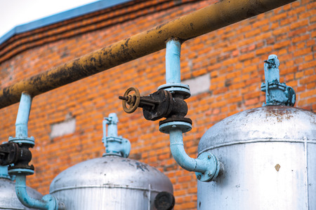 Huge oil, gas and liquid storage tanks in open air field at factory. Oil plant in the middle of Caspian Sea. Pipeline production and control valve for oil and gas process.の写真素材