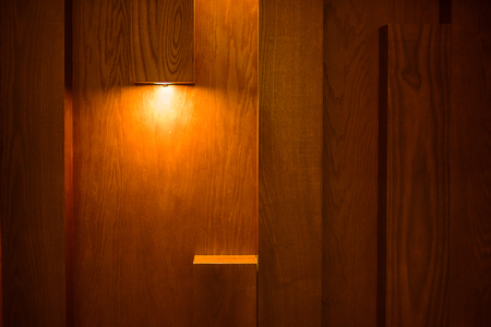 Planks brown wooden panel wall with two dimming downlight lights from top background textureの写真素材