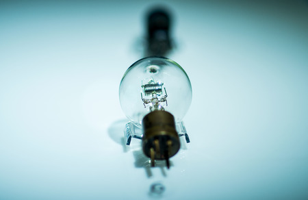 old incandescent lamp, vintage generator with clipping path rarity perspective on blue background