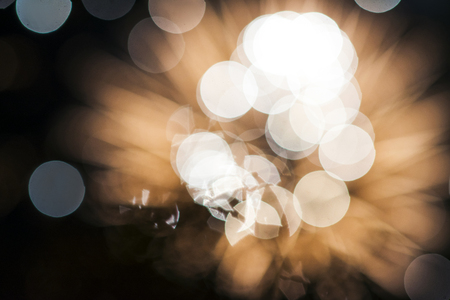 Abstract golden blurred glitter isolated on a black background. Festive golden bokeh. Bright sparkles. Concept of Christmas and New Year holidays. Free space for text or advertisement.の写真素材