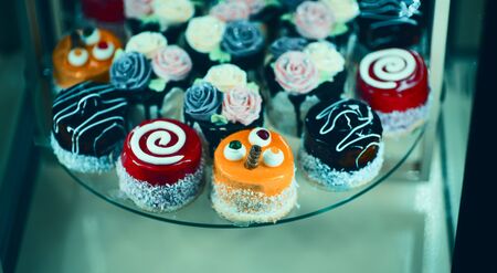 Close up view of various sweet cupcakes, selectively focused, against a bokeh background.
