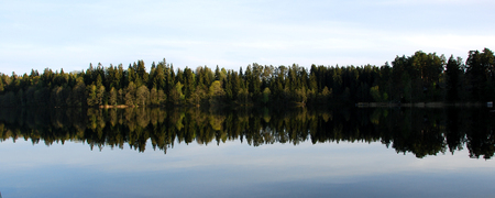 on a sunny day without wind on the lake reflected in the forest.の写真素材