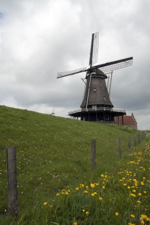 View at a windmill - Old windmill on the dike at medemblik- The Netherlands の写真素材