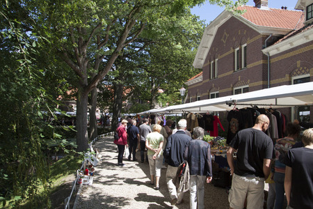 ENKHUIZEN, THE NETHERLANDS - JULY 18.2015: People walking across the market in a beautiful park with homes on a sunny day on july 18, 2015 in Enkhuizen, Holland.のeditorial素材