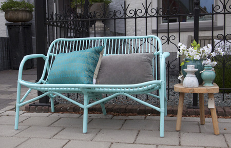 Vintage bamboo chair or sofa and pillows with pastel colors and still life on a garden table.の写真素材