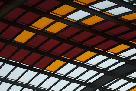 Metal roof with glass colored in red white and orangeの写真素材