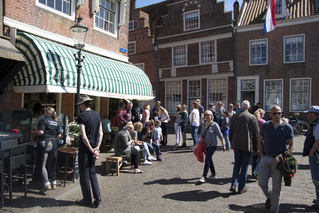 ENKHUIZEN, THE NETHERLANDS - MAY 5, 2016: Tourists enjoying the beautiful weather and a cup of coffee and drink on a terrace and walk through the cityon May 5, 2016 in Enkhuizenのeditorial素材