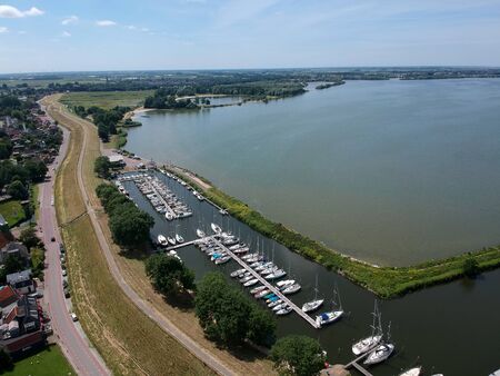 Overview drone photo of the marina at the north dutch andijk. with adjacent the village and the IJsselmeer where the sailing boats sailの写真素材